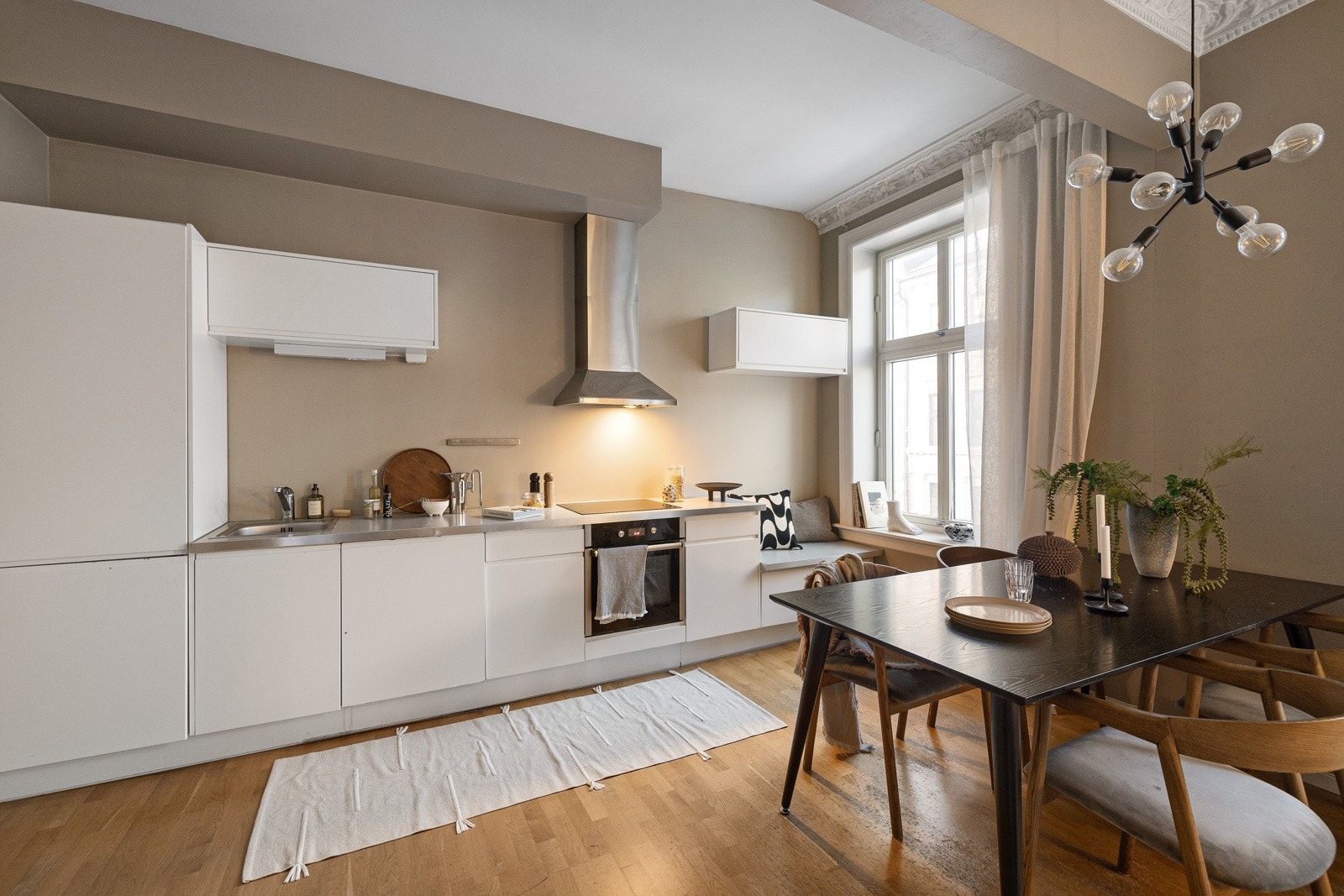 God plass til stort spisebord som deler rommet inn i naturlige soner. Galleribilde