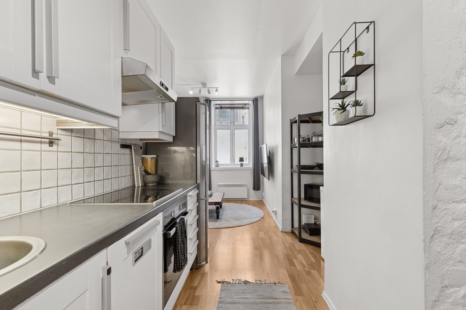 Innholdsrikt kjøkken med opplegg til oppvaskmaskin og integrerte hvitevarer Galleribilde