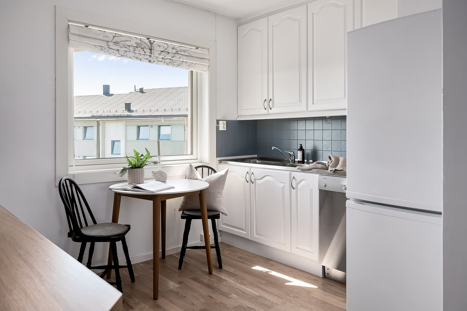 Kjøkkenet ligger naturlig tilbaketrukket fra stuen og har lyse slette flater og benkeplate av laminat og rustfritt stål. Galleribilde