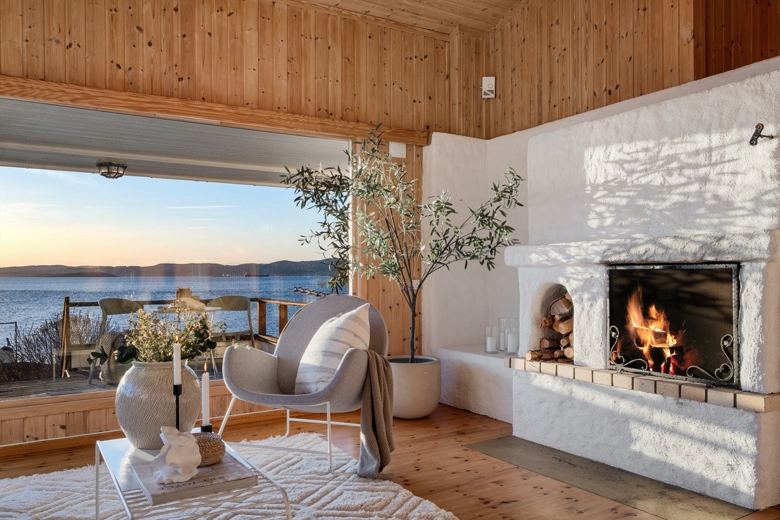 En innmuret, åpen peis i stuen sørger for både hygge og varme på kjølige dager. Galleribilde
