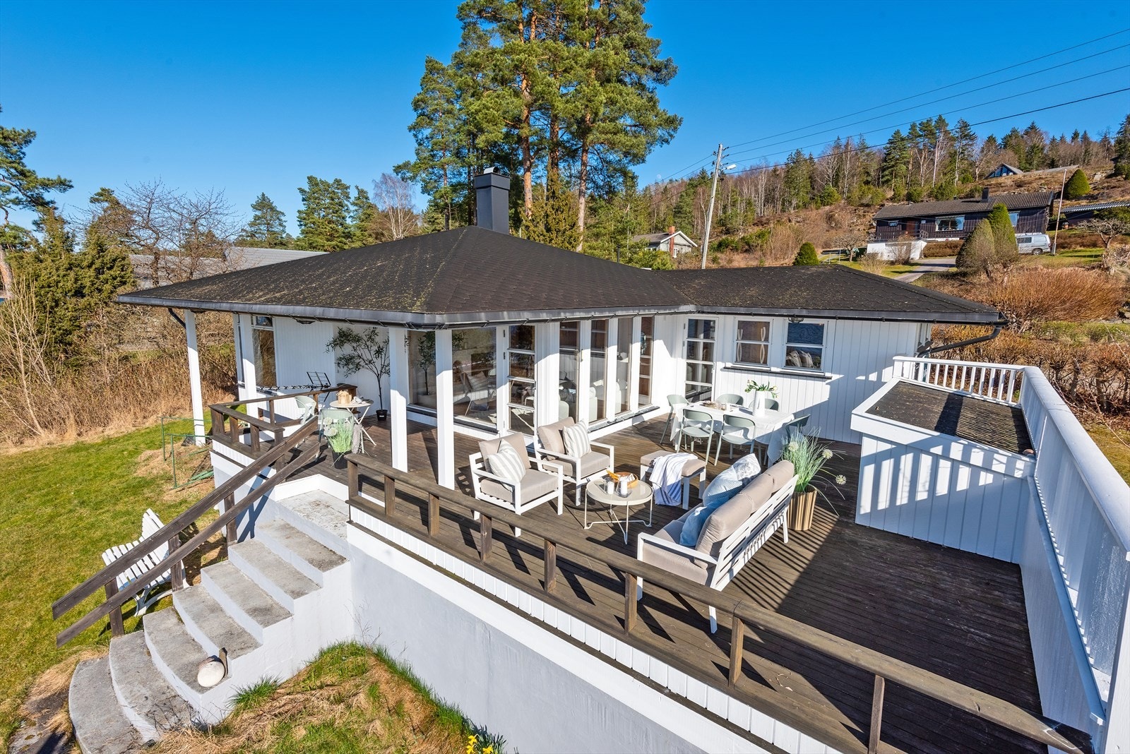 Fra veranda fører en steintrapp fører ned til gressplen med boltreplass for liten og stor. Galleribilde