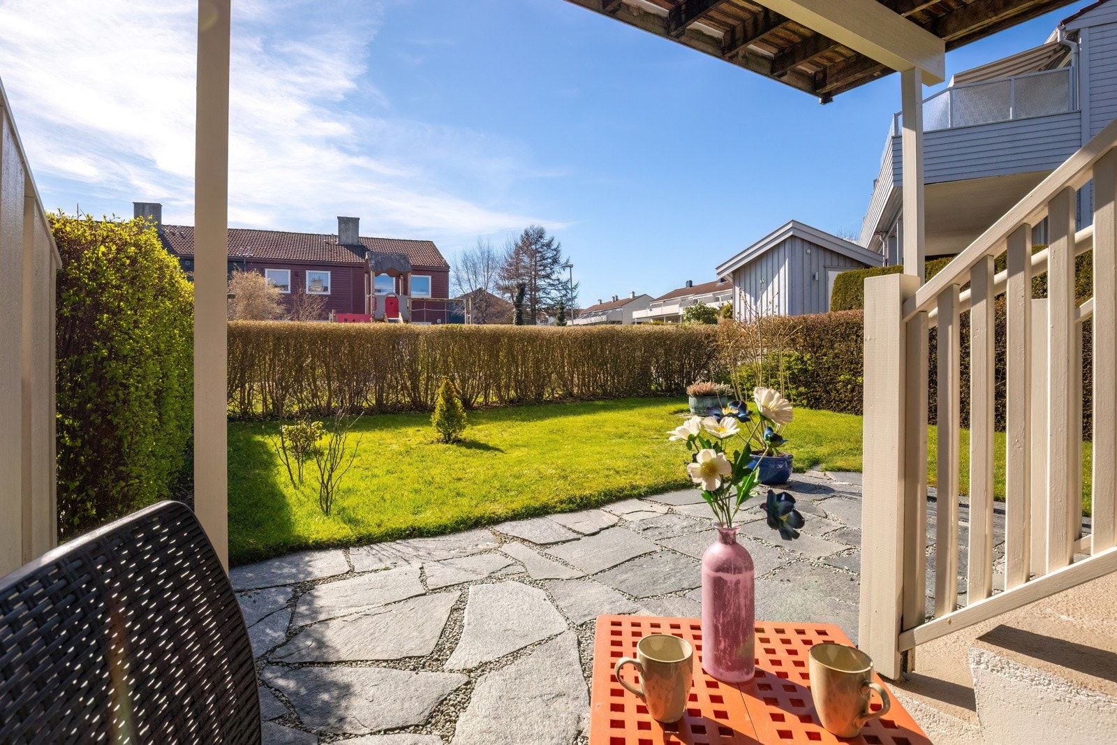 Fra 1. etasjen er det utgang til hage med gressplen og skiferstein Galleribilde