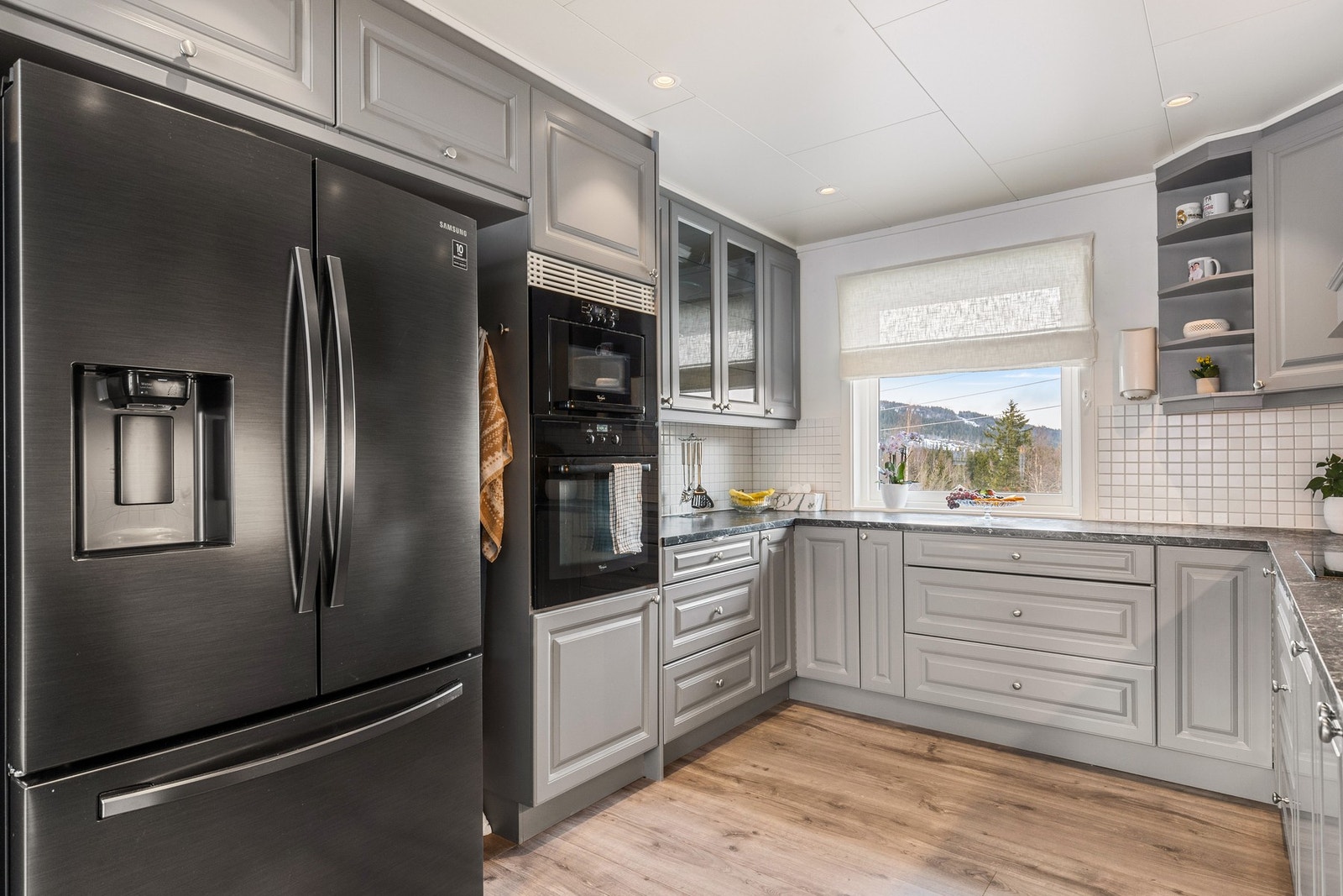 Kjøkkenet har integrerte hvitevarer som stekeovn, mikro, platetopp og oppvaskmaskin Galleribilde