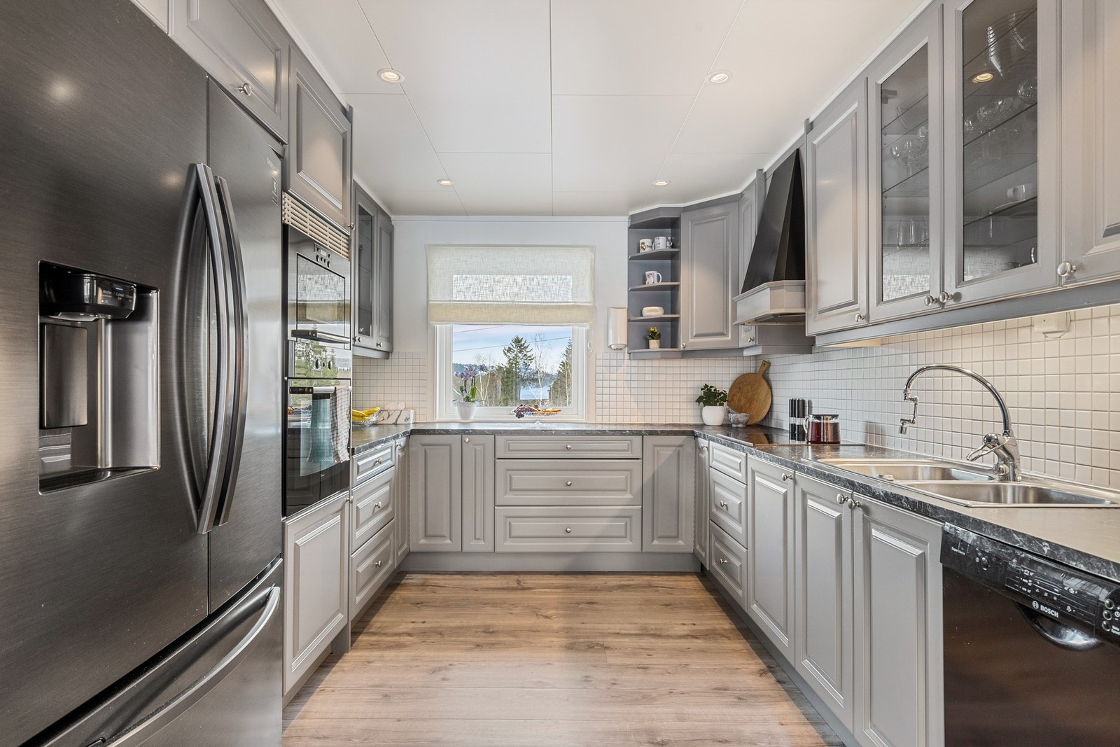 Pent kjøkken som holder et tidløst preg og har godt med skap og benkeplass Galleribilde