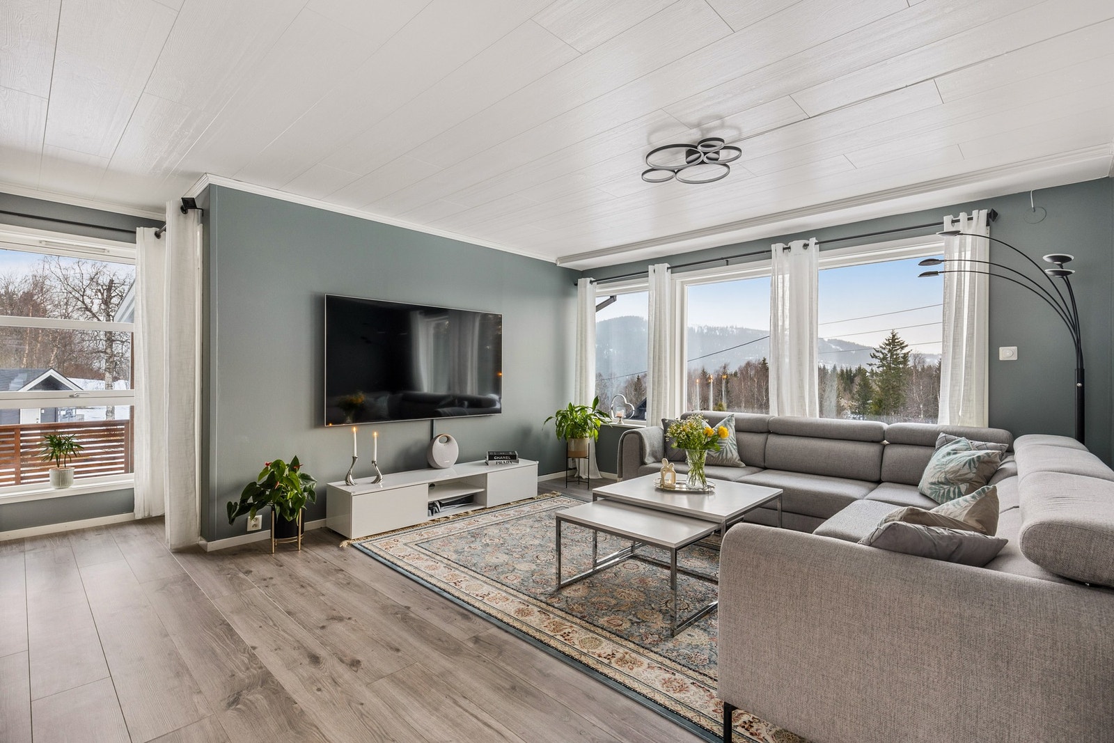 Lys og romslig stue med flere sone-inndelinger. Tidsriktige fargevalg på overflatene Galleribilde