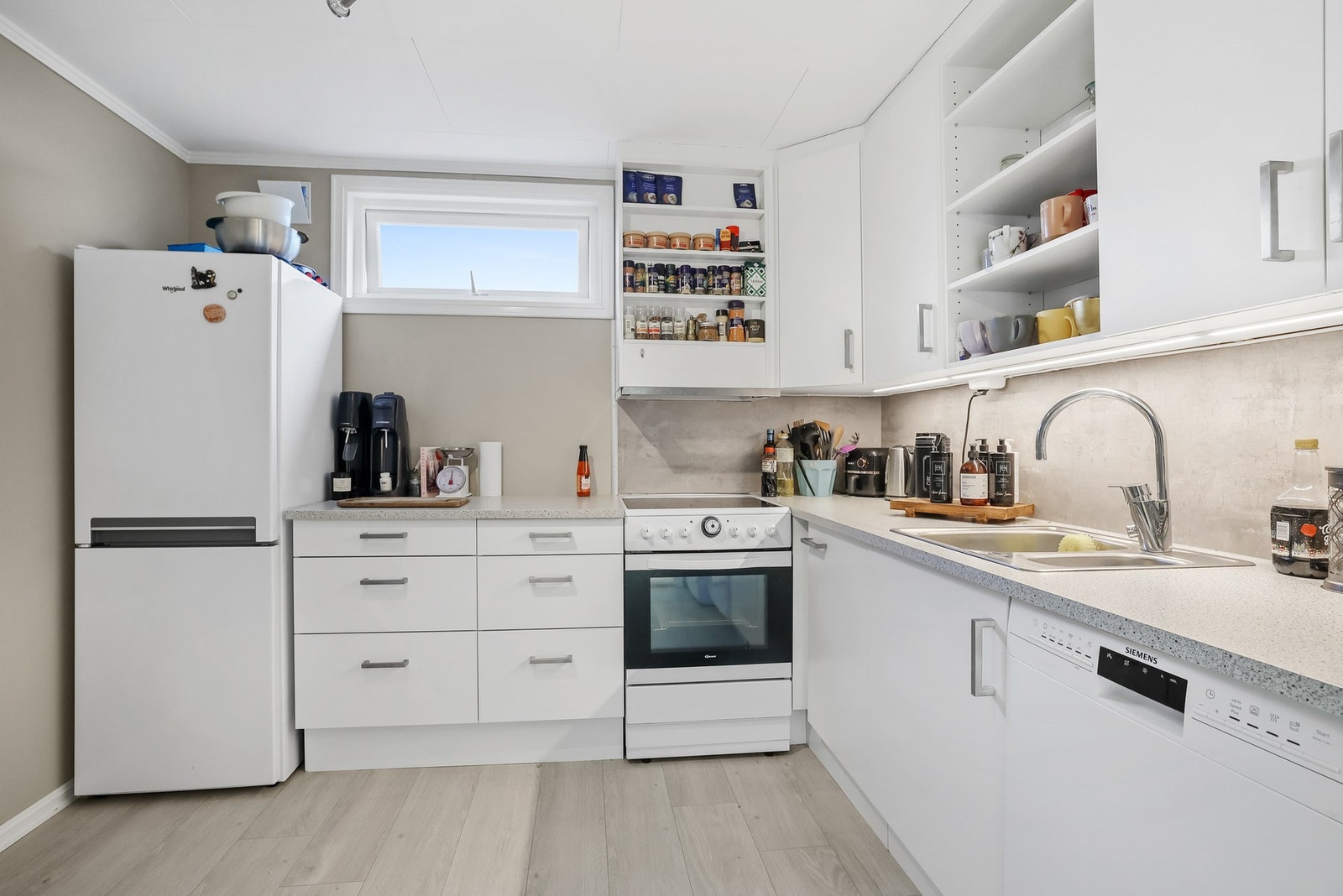 Kjøkkenet i utleiedelen har en praktisk løsning med et mindre vindu som gir noe dagslys Galleribilde