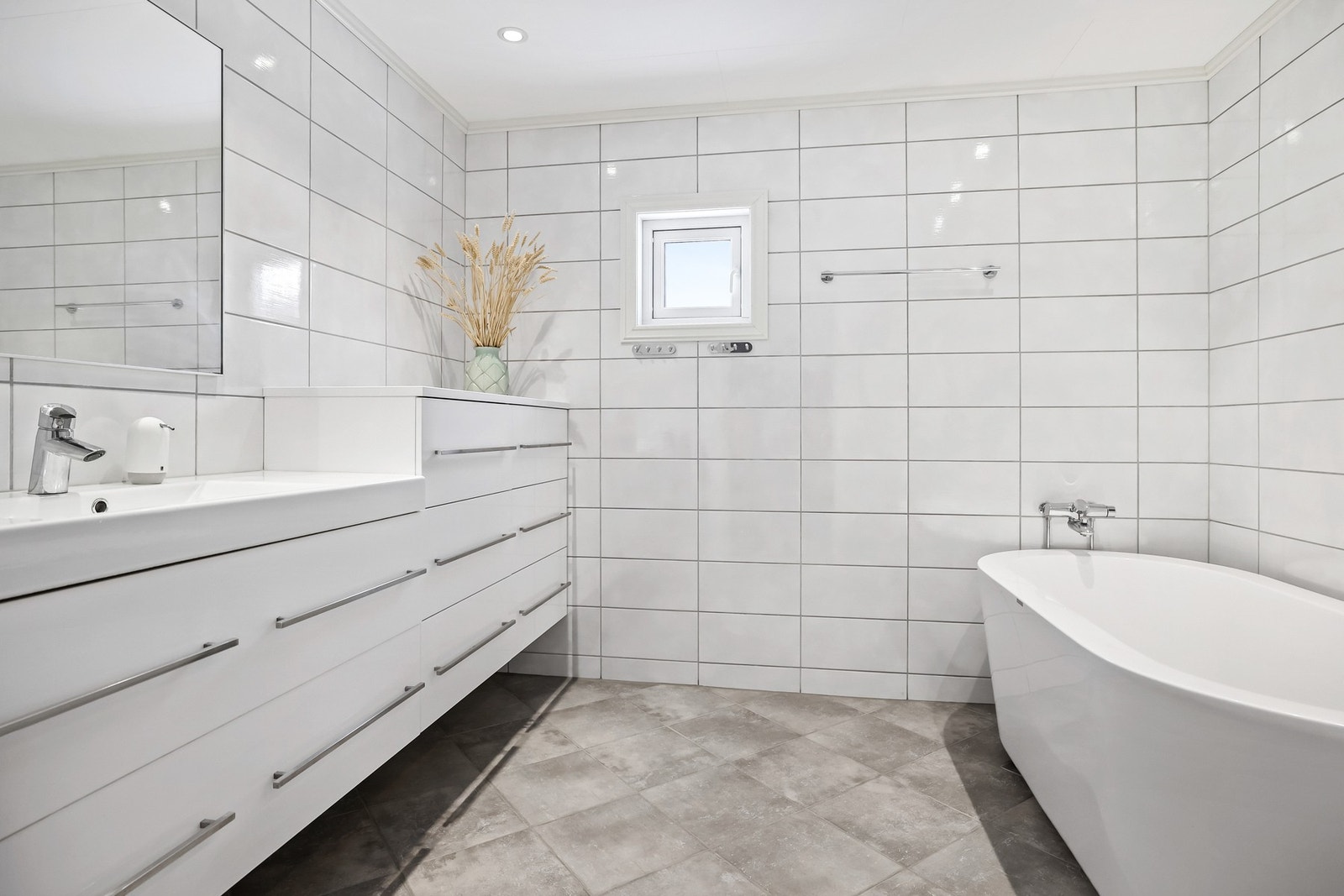 Badet er flislagt med lyse fliser og en moderne innredning. Galleribilde