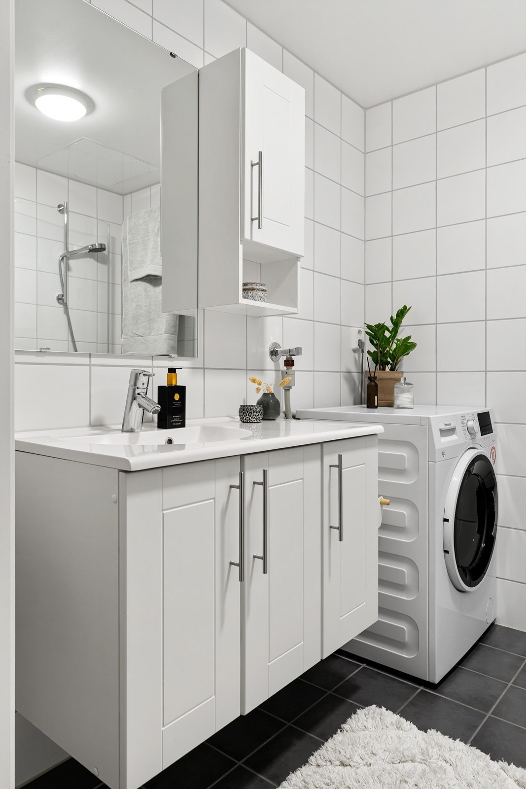 Badet holder et lyst og tidløst preg med sine flislagte overflater. Oppvarmes med varme i gulv. Galleribilde