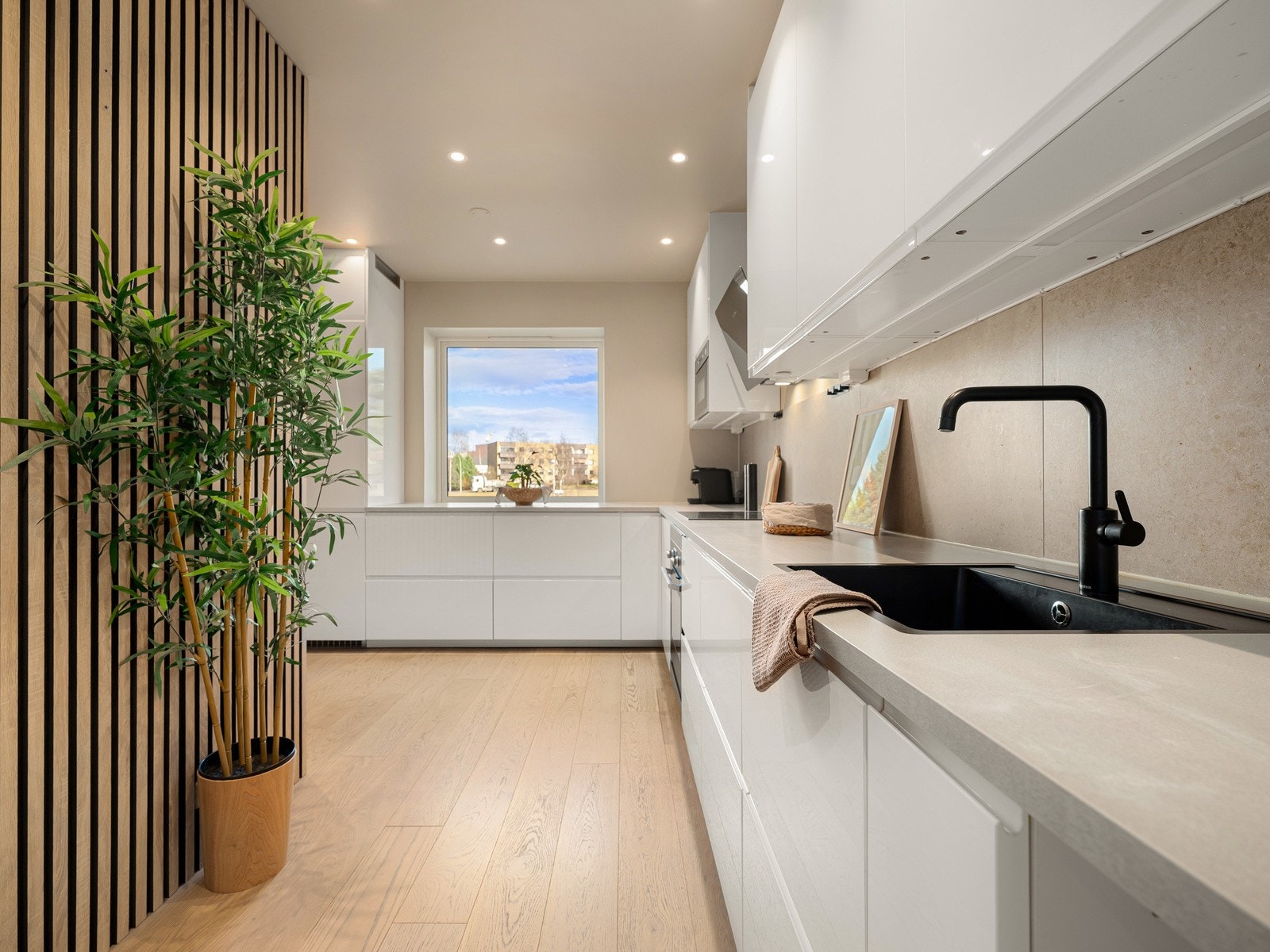 Fra entréen og inn mot stuen ligger det lekre kjøkkenet - praktisk og sentralt plassert i boligen. Galleribilde