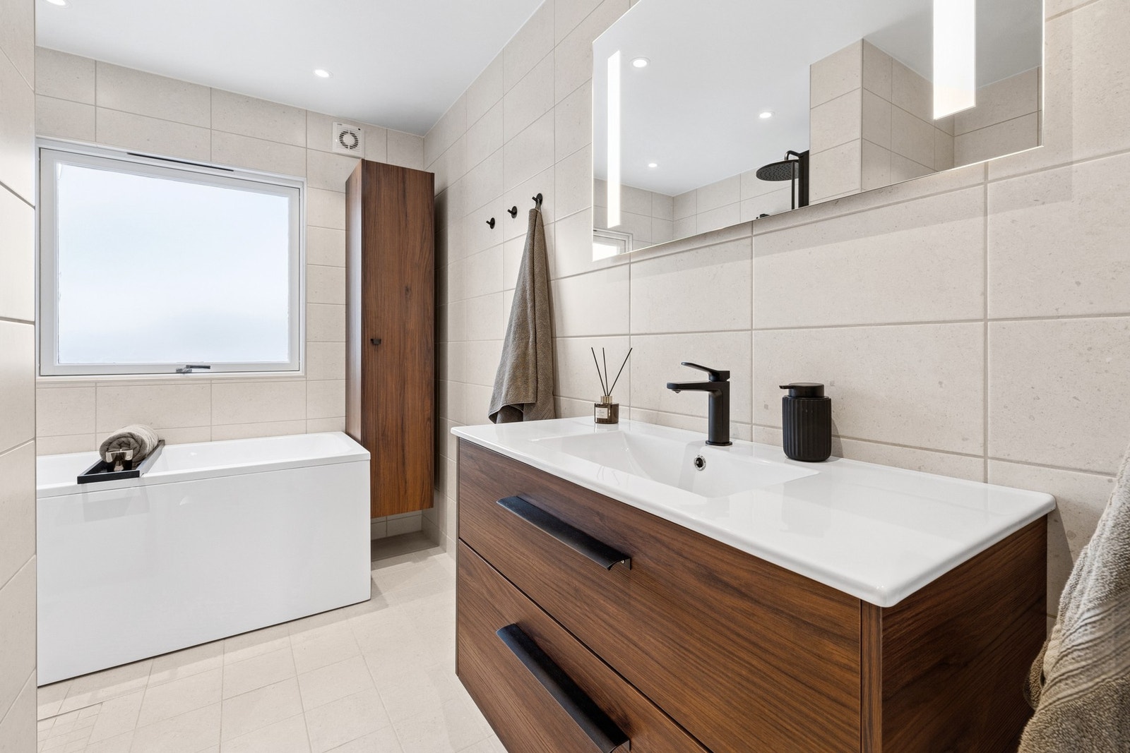 Her får du et godt utstyrt baderom med sorte armaturer og tidsriktig innredning som gir et stilrent og eksklusivt preg. Galleribilde