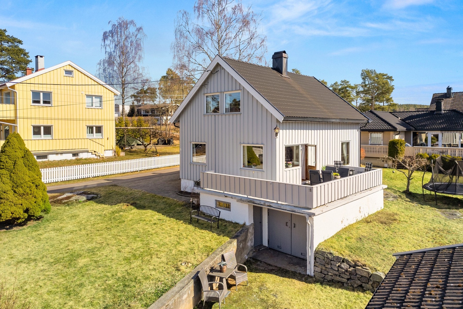 Tomten er solrik, velstelt og pent opparbeidet med store plenarealer, beplantning og støpte støttemurer. Galleribilde