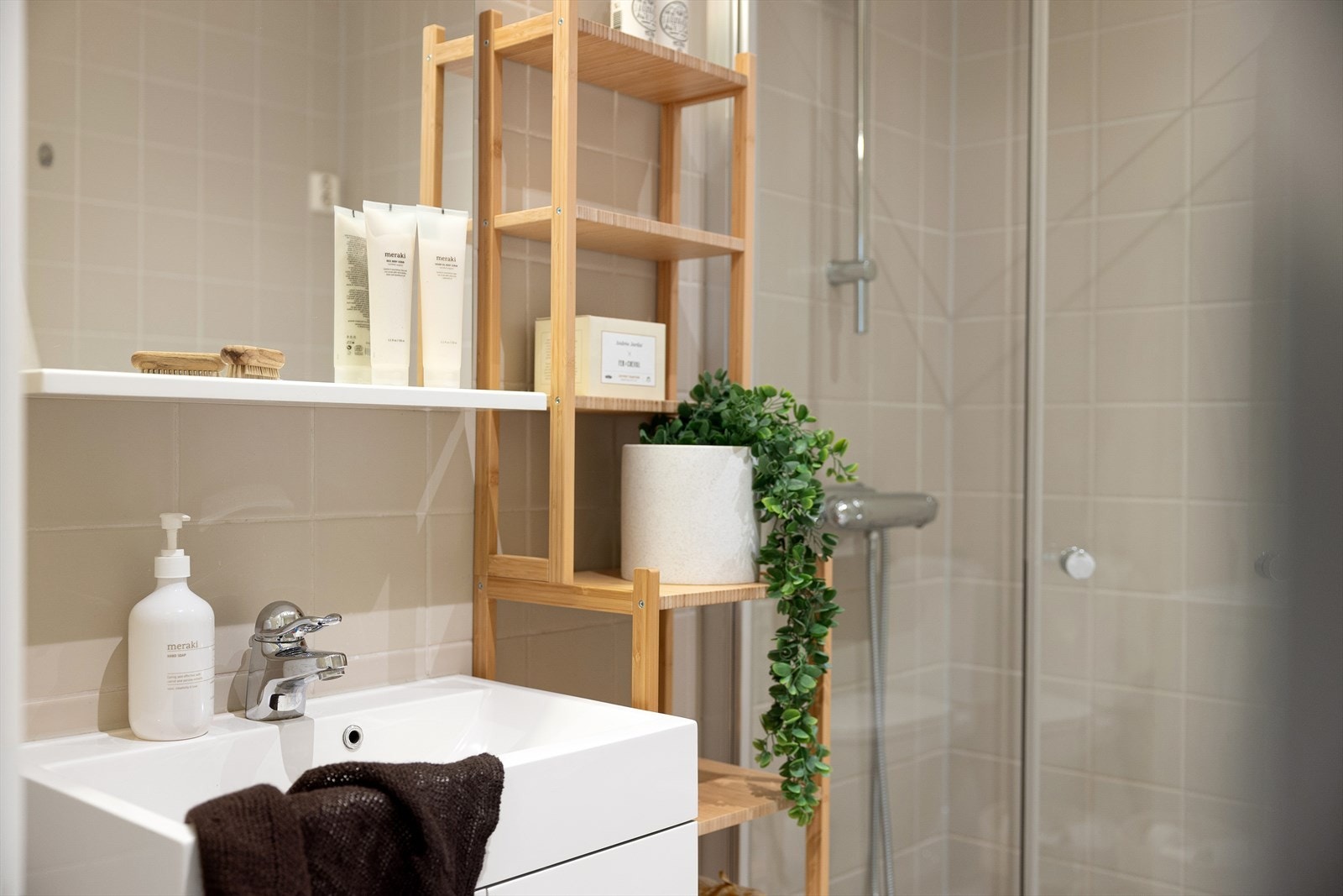 Badet har servant, skap, speil, belysning og gulvstående toalett. Dusjhjørnet er utstyrt med vegg og dør i herdet glass. Galleribilde