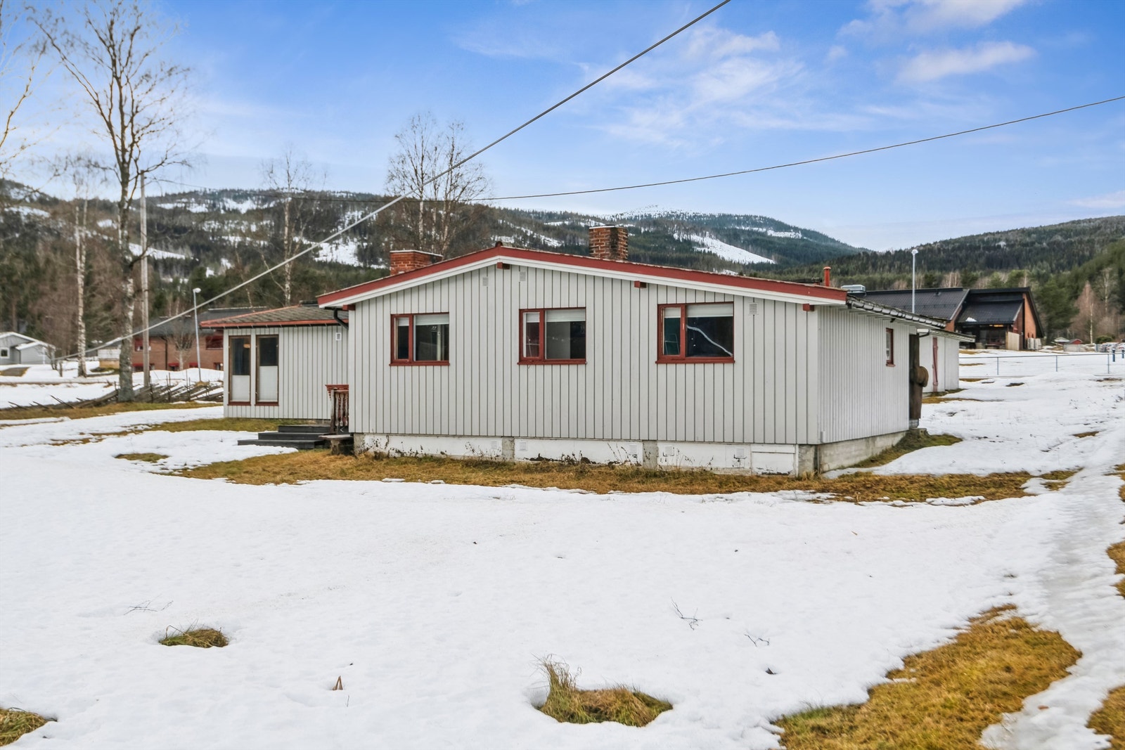 Tomten er svakt hellende og fordelt på to nivåer. Den er opparbeidet med plen og beplantning. Galleribilde