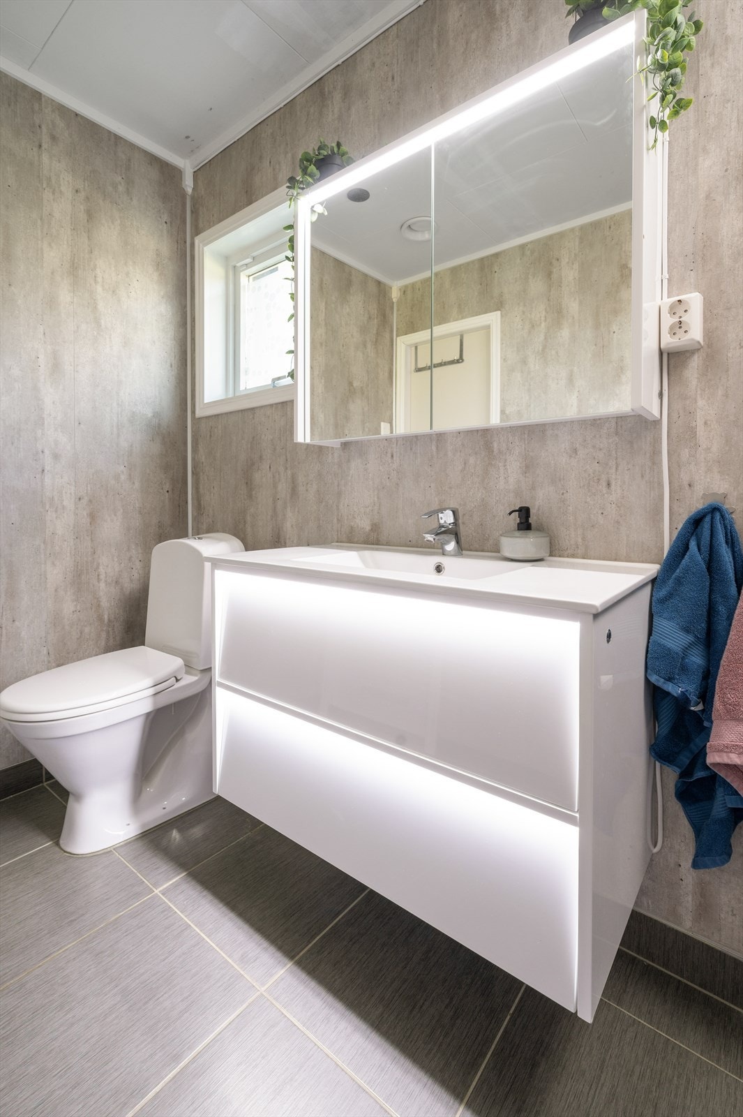 Rommet er utstyrt med dusjkabinett, gulvstående toalett og en moderne innredning m/belysning Galleribilde