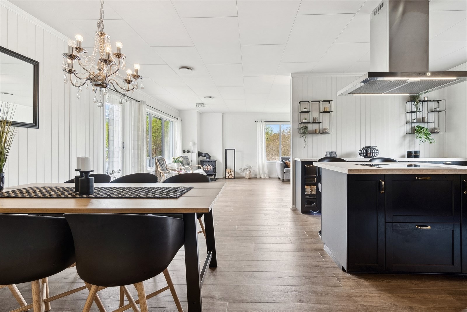 Kjøkkenet ligger i delvis åpen løsning mot spisestuen og har en moderne sort innredning fra ca. 2020 Galleribilde