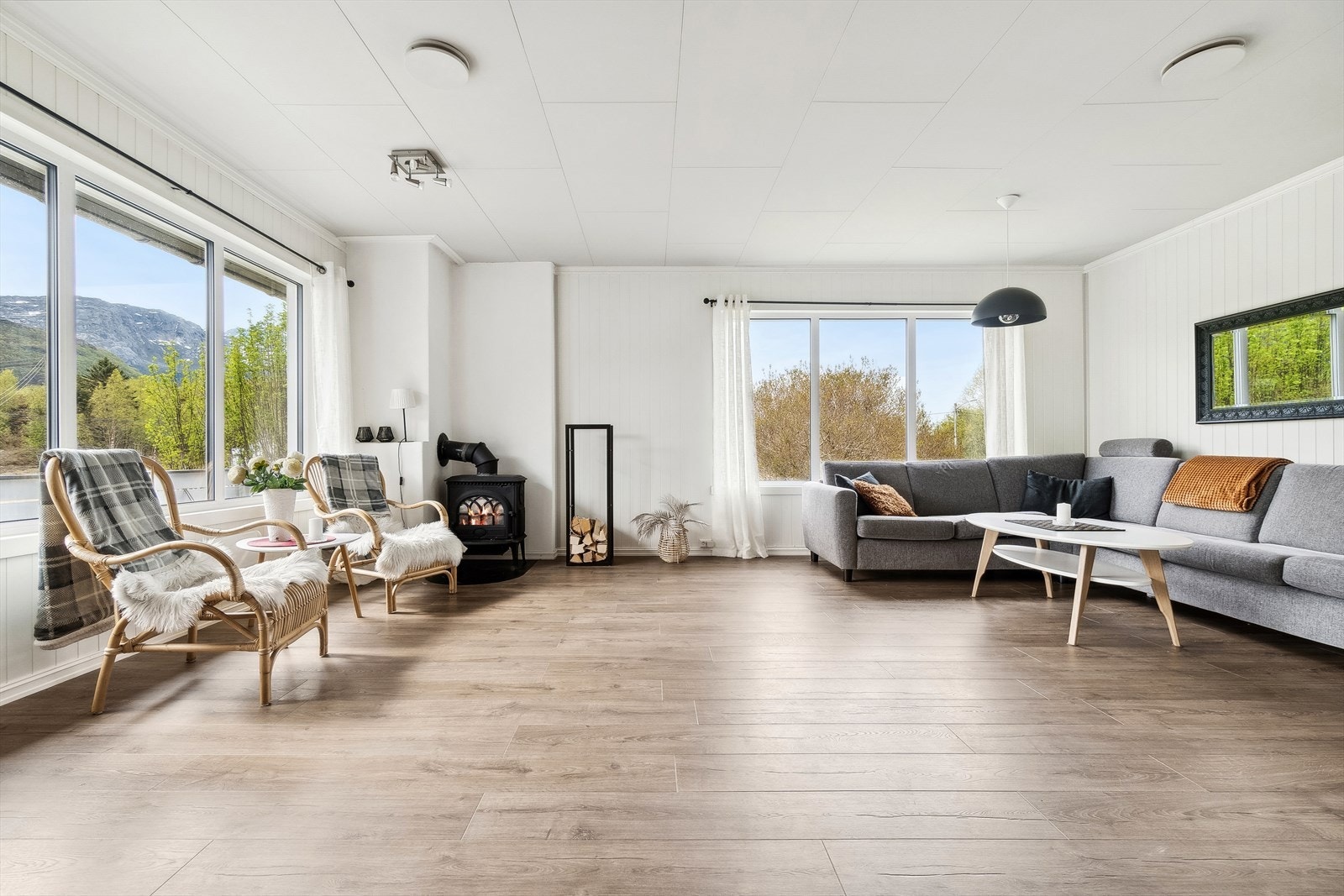 Stuen byr på store vindusflater og er utført med et 1-stavs laminatgulv og hvitmalte overflater Galleribilde