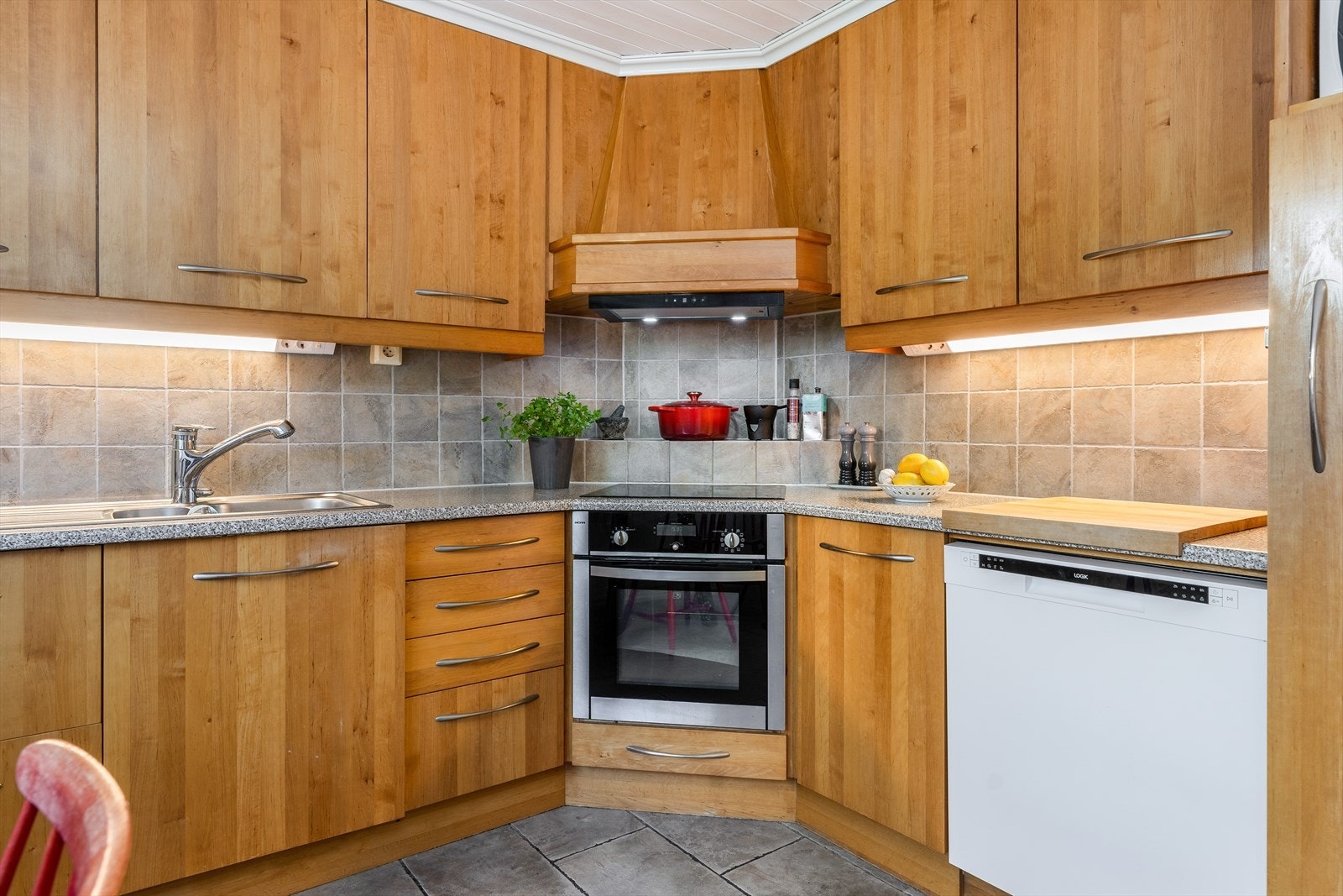 Kjøkkenet har innredning med glatte fronter og benkeplate av laminat med flis over. Det er god skap- og benkeplass. Galleribilde