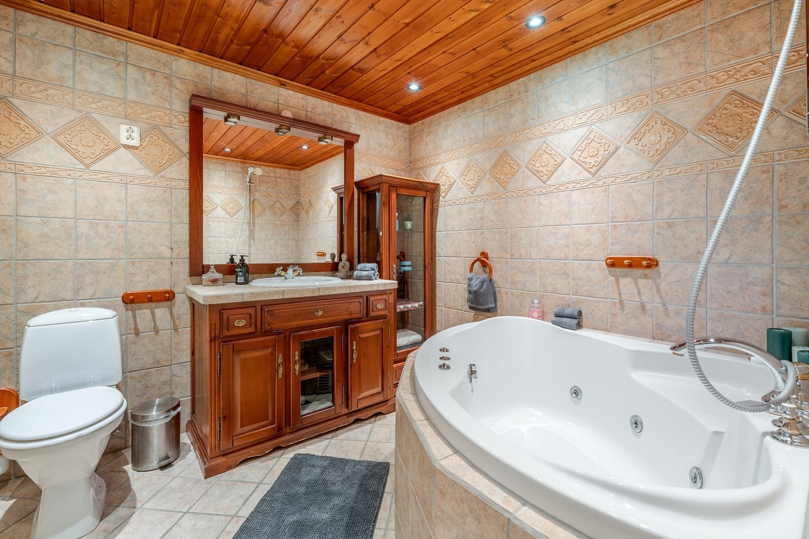 Romslig, flislagt bad med varmekabler i gulv og spotter i tak. Galleribilde