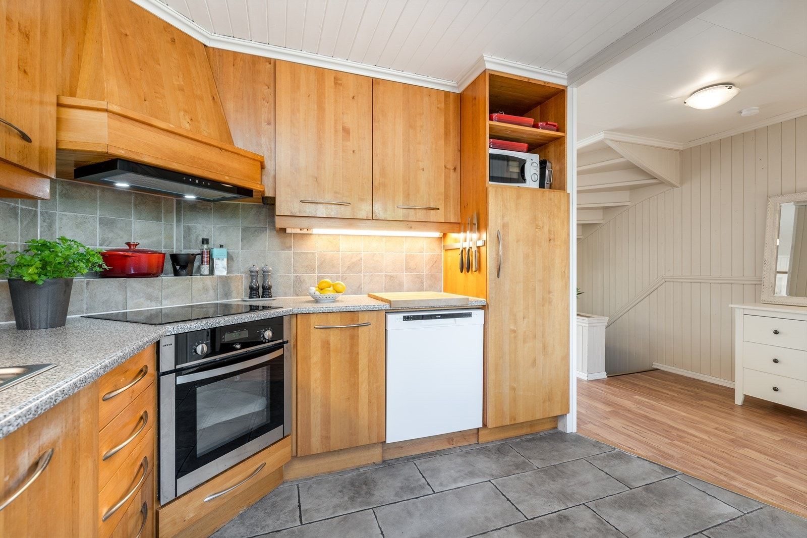 På kjøkken er det flislagt gulv med varmekabler, panelplater på vegger og trepanel i taket. Galleribilde