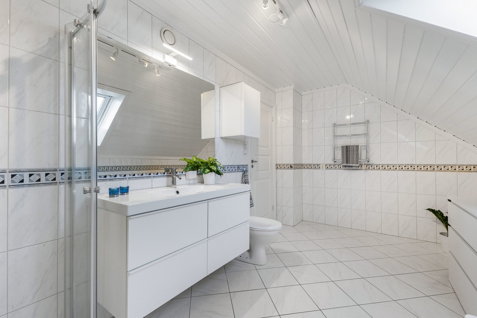 Her finner du dusjhjørne, badekar, toalett og en stilren baderomsinnredning. Galleribilde