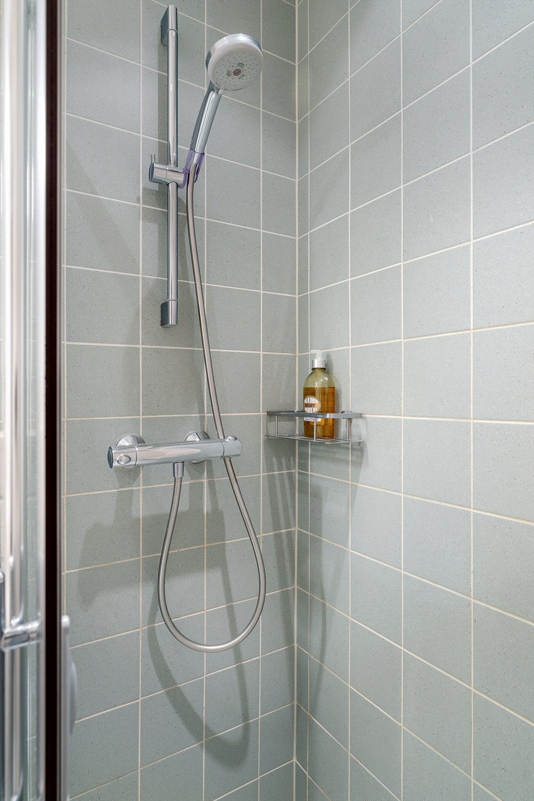 Romslig dusjnisje med faste felt og dør i herdet glass. Galleribilde