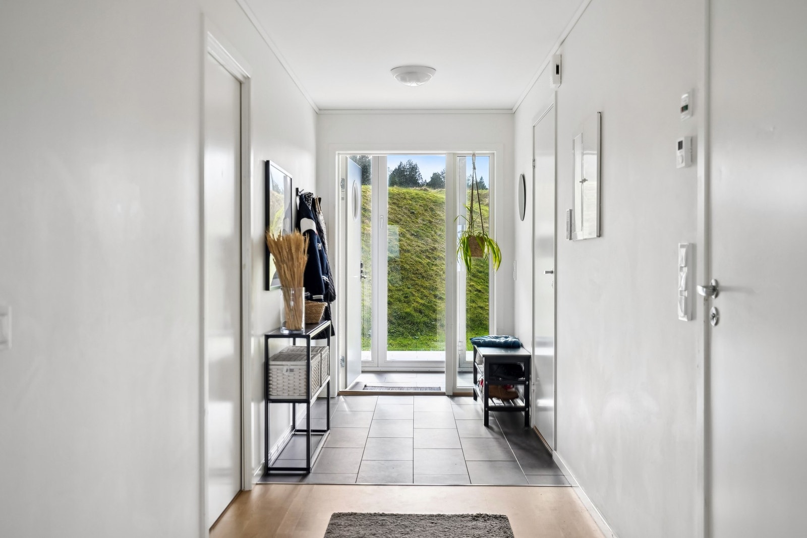 Entréen er lys og pen med plass til oppbevaring av yttertøy og sko. Galleribilde