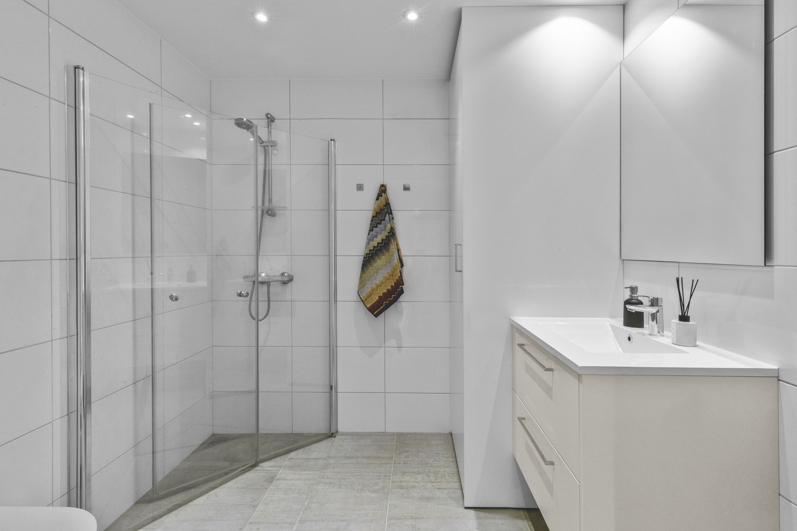 Stilrent bad med spotter i himling og god inndeling av baderomsmøblement Galleribilde