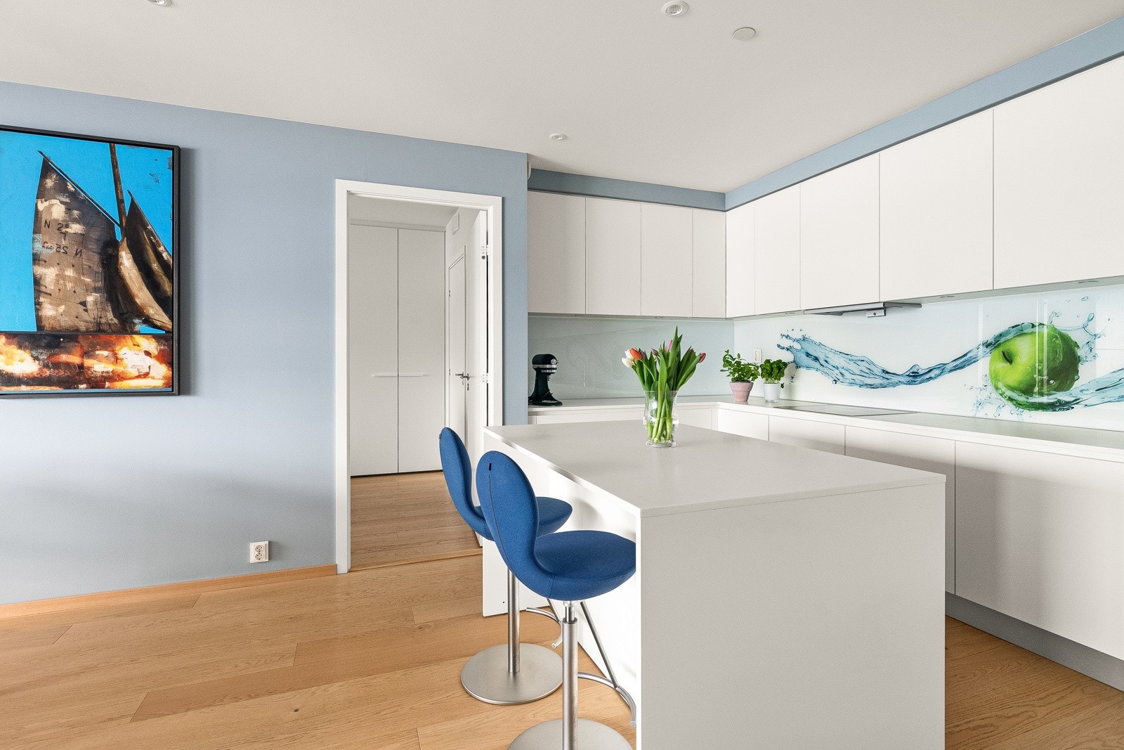 Videre er kjøkkenet utstyrt med stor kjøkkenøy i samme utførelse som øvrig kjøkkeninnredning med integrert vinskap, samt ekstra med benke- og skapplass. Galleribilde