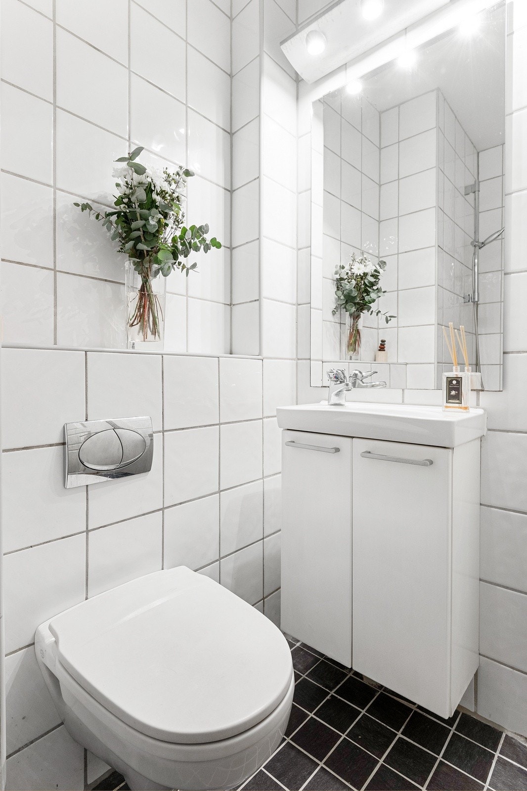 Badet er utsyrt med varmekabler i gulv, dusjnisje, vegghengt toalett og servant med underskap. Galleribilde