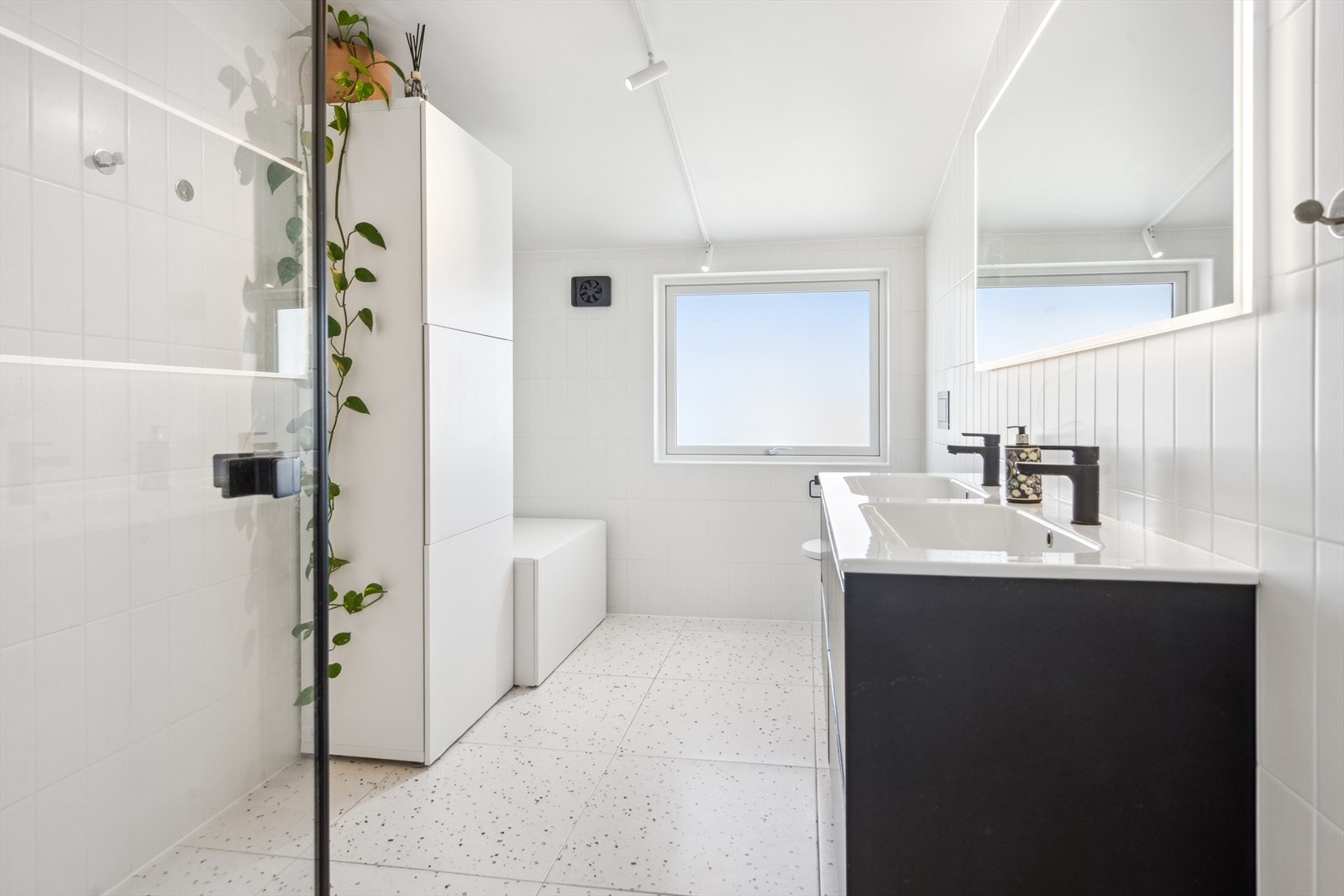 Badet i 2. etg. ble bygget i 2023, og har lyse fliser og sort innredning og detaljer. Galleribilde