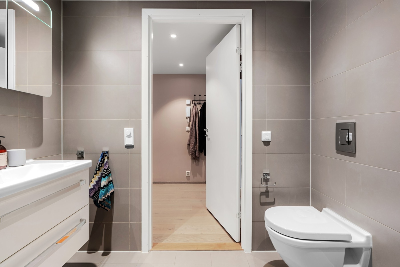 Leiligheten har et pent og delikat bad med inngang fra entréen Galleribilde