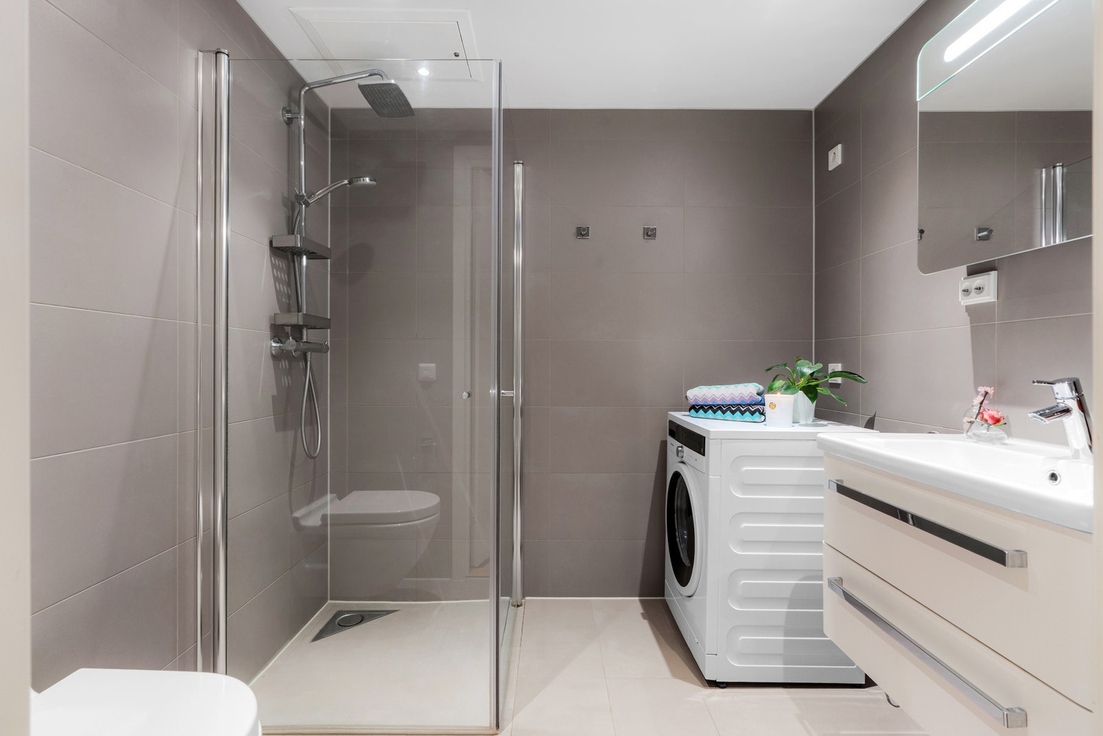 Badet har vannbåren gulvvarme, downlights i tak og opplegg for vaskemaskin Galleribilde