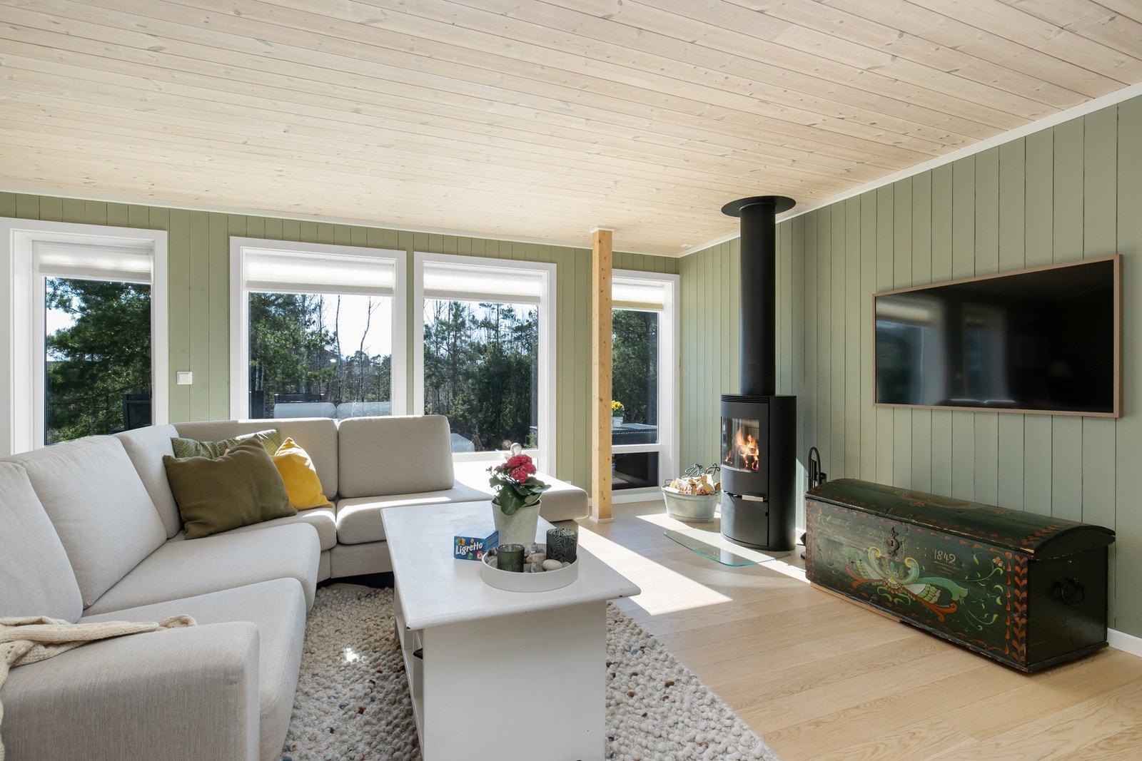 Åpen og lys stue med nydelig utsyn til naturen - her får du en harmonisk kombinasjon av moderne komfort og klassisk hyttestil. Galleribilde