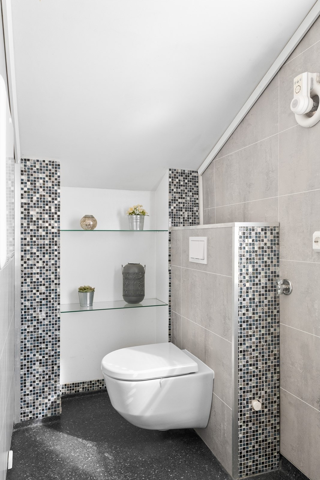 Badet er innredet med dusjkabinett, baderomsinnredning med servant, badekar og vegghengt toalett. Galleribilde