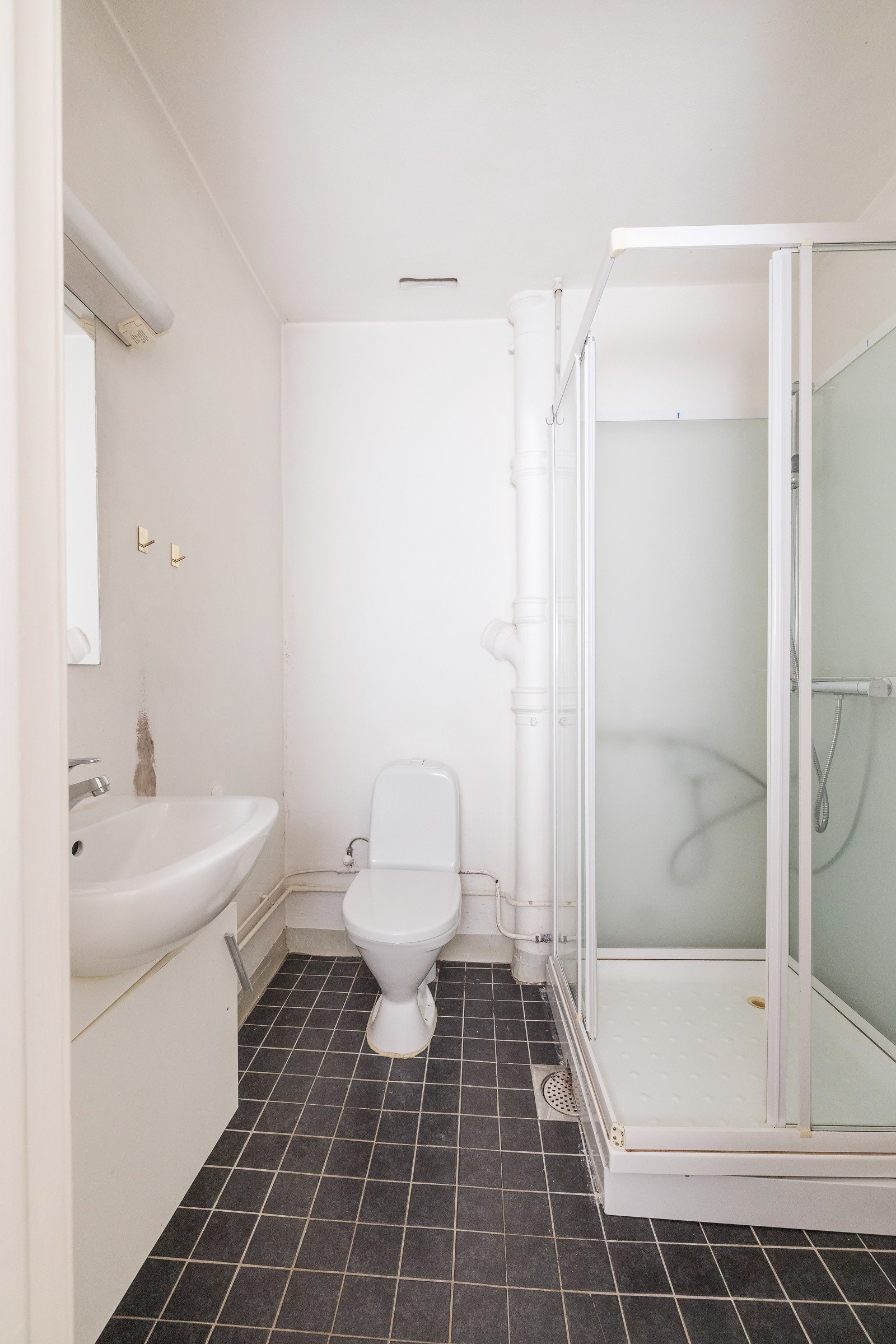 Eldre bad med naturlig avtrekk, opplegg for vaskemaskin, wc og dusjkabinett med glassskyvedører. Galleribilde