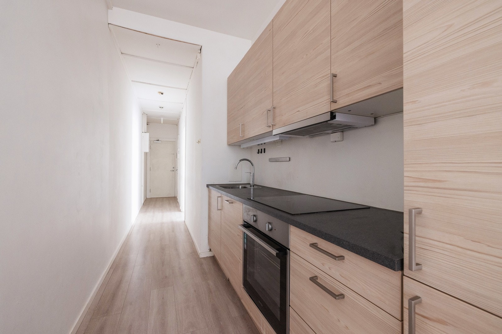 HTH-kjøkkeninnredning med slette og plastlaminerte fronter. Innredning med kullfiltervifte over stekesonen. Galleribilde