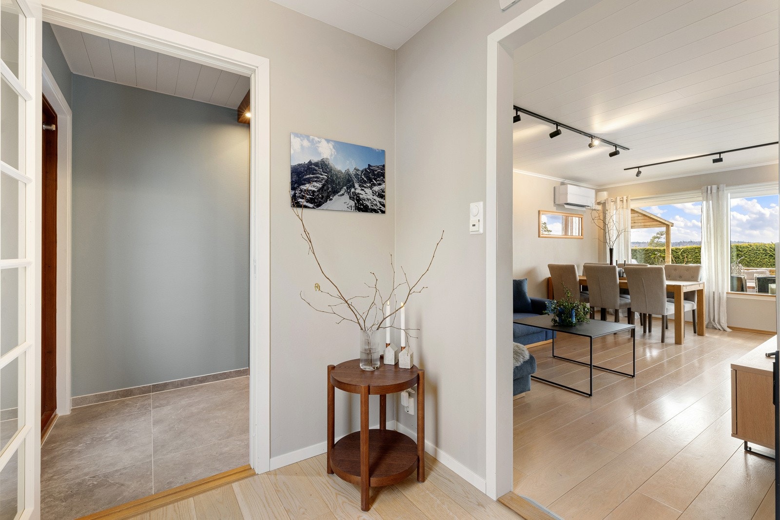 Entréen har malte vegger og flislagt gulv. Galleribilde