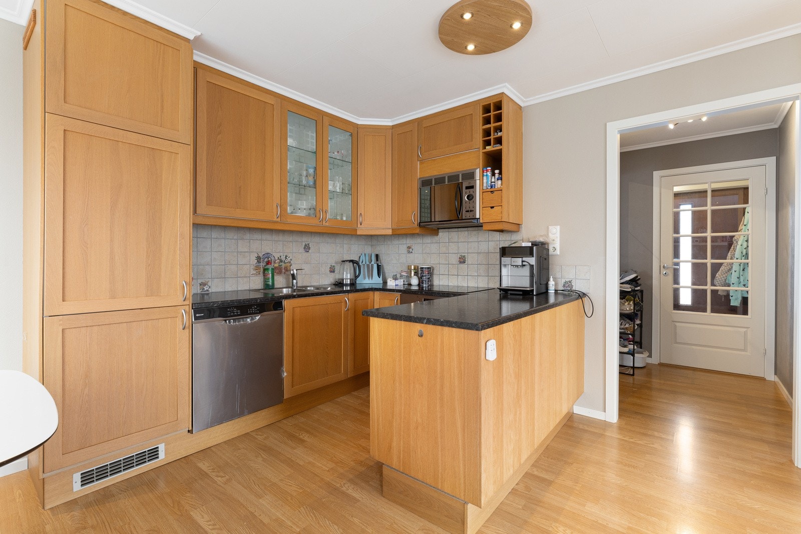 Kjøkkenet har eikefronter og laminerte benkeplater med nedfelt oppvaskkum og er innnredet med integrerte hvitevarer som induksjonstopp, komfyr, micro og kjøleskap med frysedel, mens det er avsatt plass for oppvaskmaskin. Galleribilde