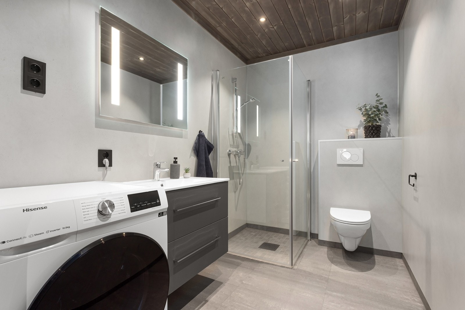 Baderom inneholder innredning med servant, dusjhjørne og veggmontert wc. Opplegg til vaskemaskin. Galleribilde