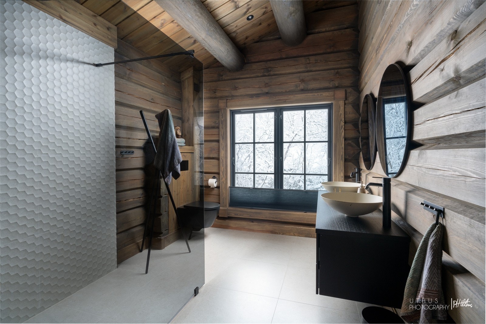 Badet i andre etasje er meget lekkert med delikate, sandfargede fliser, kombinert med mønstrede fliser på den ene veggen i dusjsonen, samt flotte tømmervegger og panel i skråhimling. Galleribilde