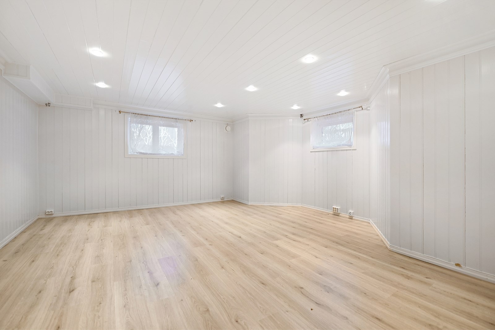 Rom brukt som stue er romslig med downlights, lyst laminatgulv og hvitmalte overflater. Galleribilde