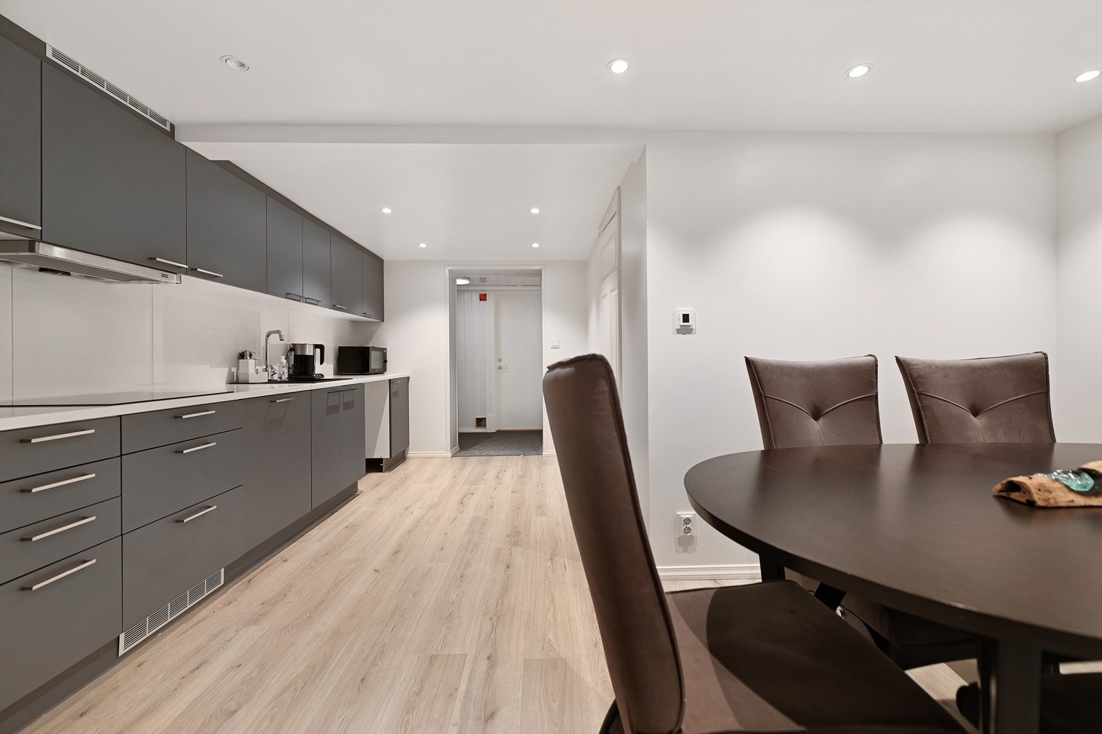 Kjøkkenet ligger adskilt fra stuen med innredning på en hel vegg, granitt benkeplate og fliser på vegg. Galleribilde