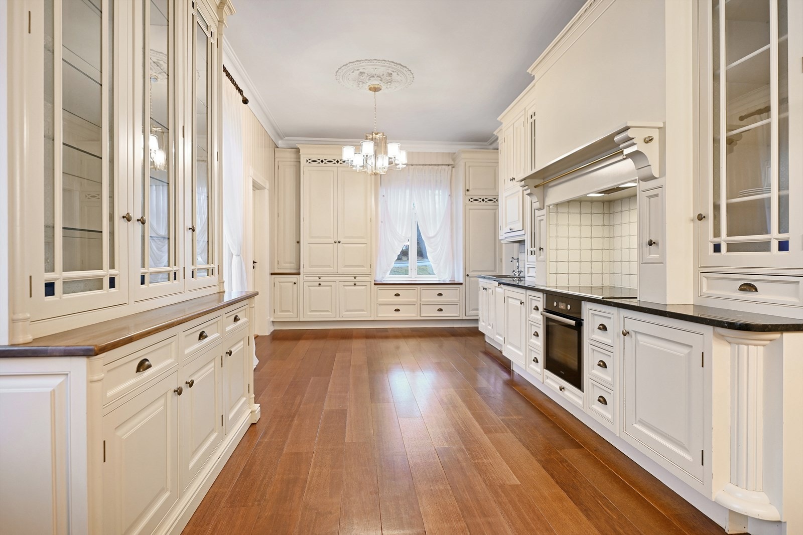 Det er lyse, klassiske fronter med delvis glass og detaljerte utskjæringer fra Øverbø Snekkerverksted. Galleribilde