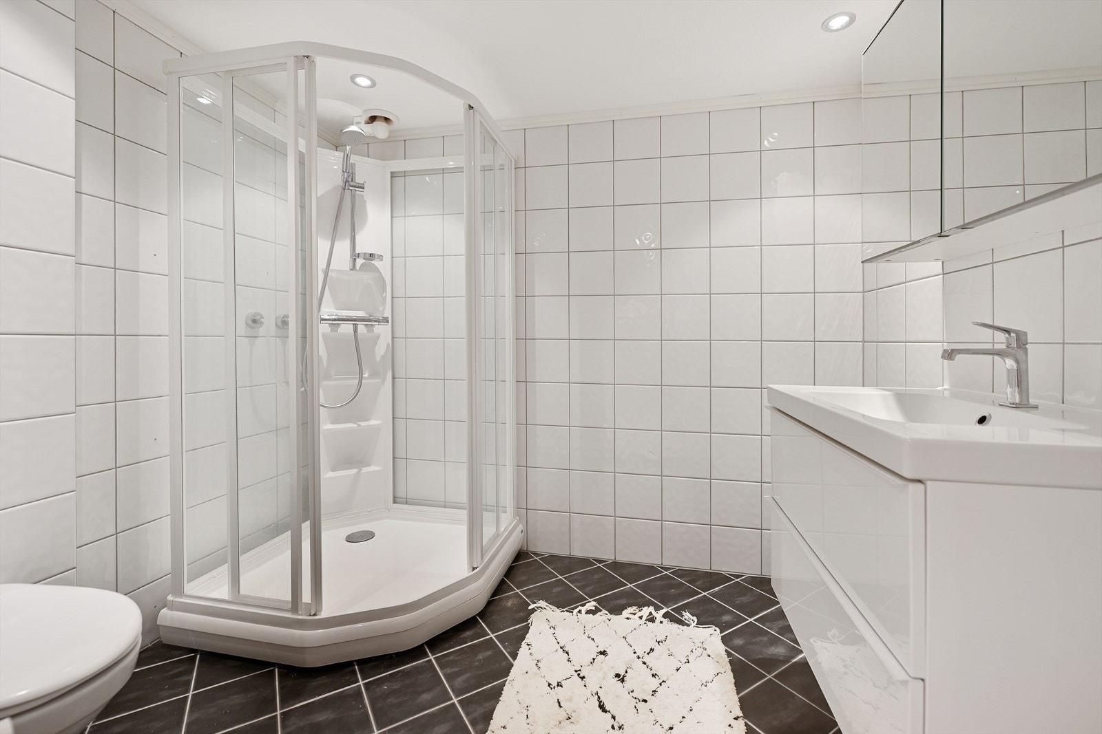 Badet i underetasje har flislagte overflater, varmekabler, downlights og tidløs innredning. Galleribilde