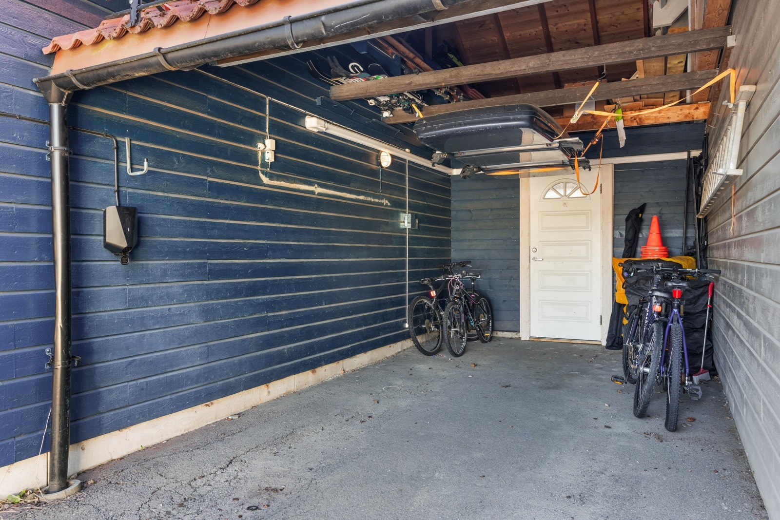 Bilen parkerer man enkelt i carporten. Her har man tilgang til elbillader. Galleribilde