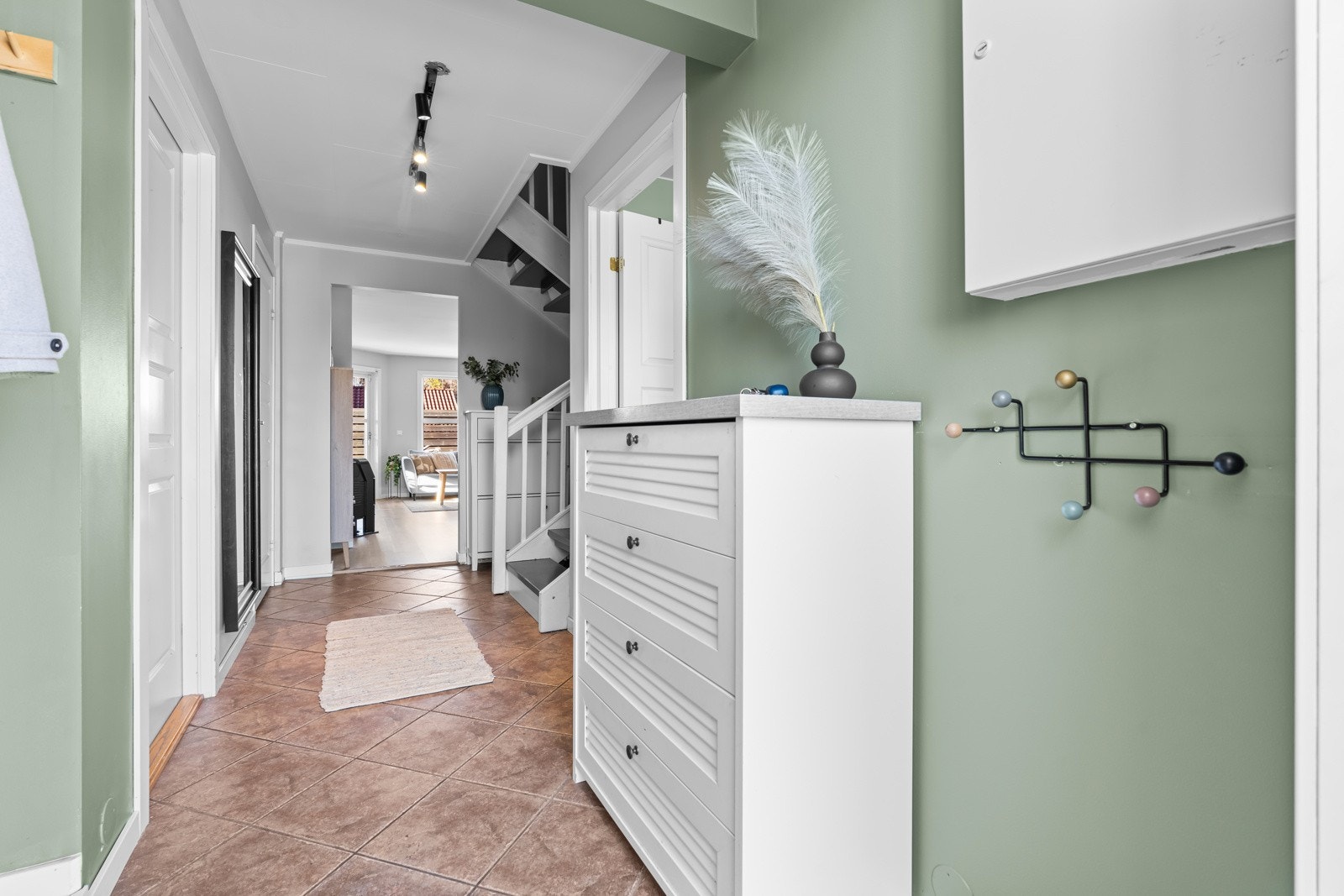 Innbydende entré med oppheng for yttertøy og plass for sko. Galleribilde