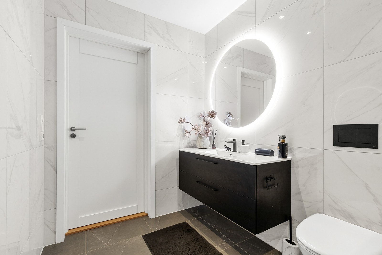 Badet er videre utstyrt med en vegghengt servantinnredning med skuffer og ovenpåliggende servant med ett-greps armatur Galleribilde