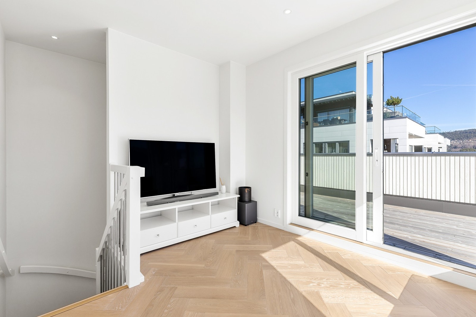 Praktisk loftsstue med fiskebensparkett på gulv og slette flater på vegger og i himling Galleribilde