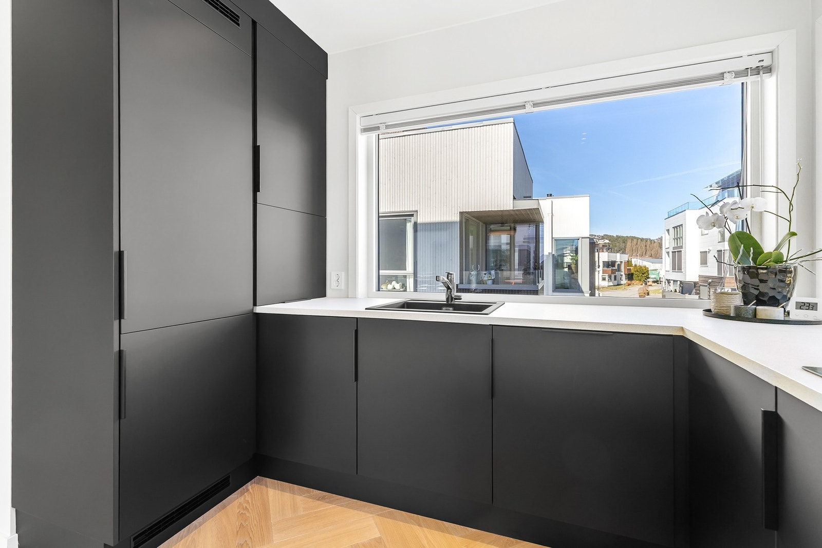 Innredningen har glatte fronter og nedfelt oppvaskkum med ett-greps kjøkkenarmatur Galleribilde