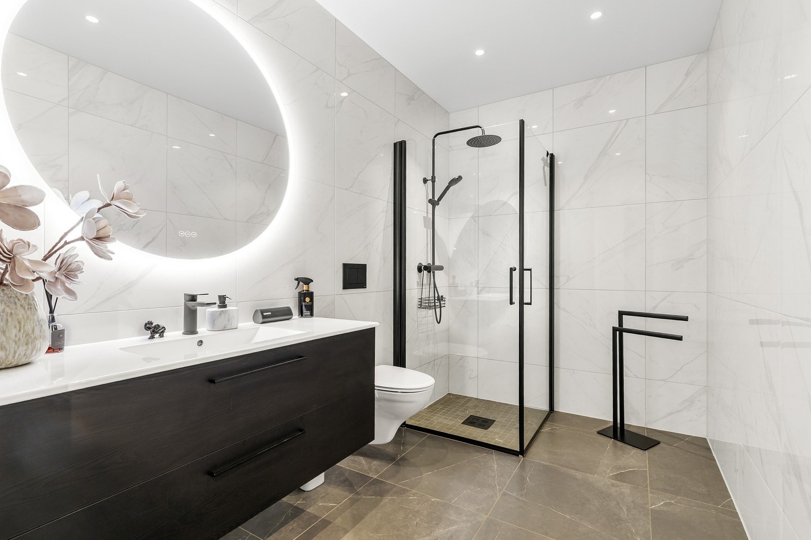 Helfliset bad med gulvvarme, innredet med vegghengt toalett og dusjhjørne med glassdører og dusjarmatur med hånddusj og regndusj Galleribilde